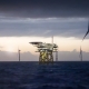 Offshore platform - substation and wind farm in sunset